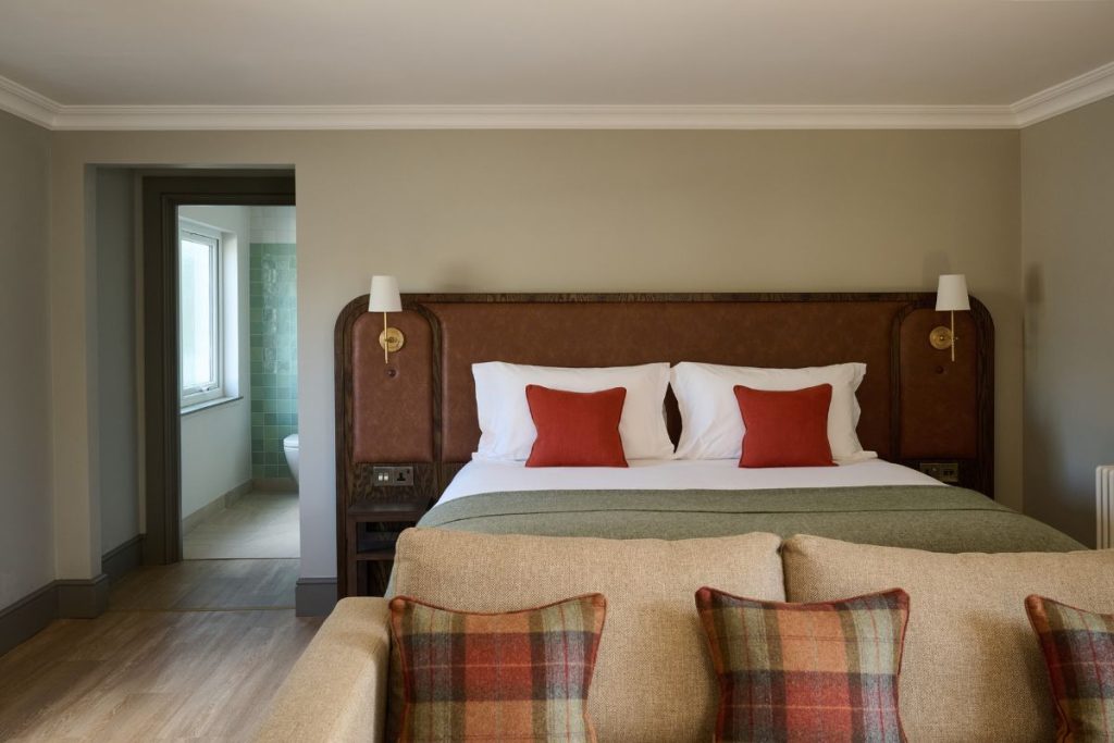 The Cottage Suite king sized bed with sofa, and cushions at The Leddie