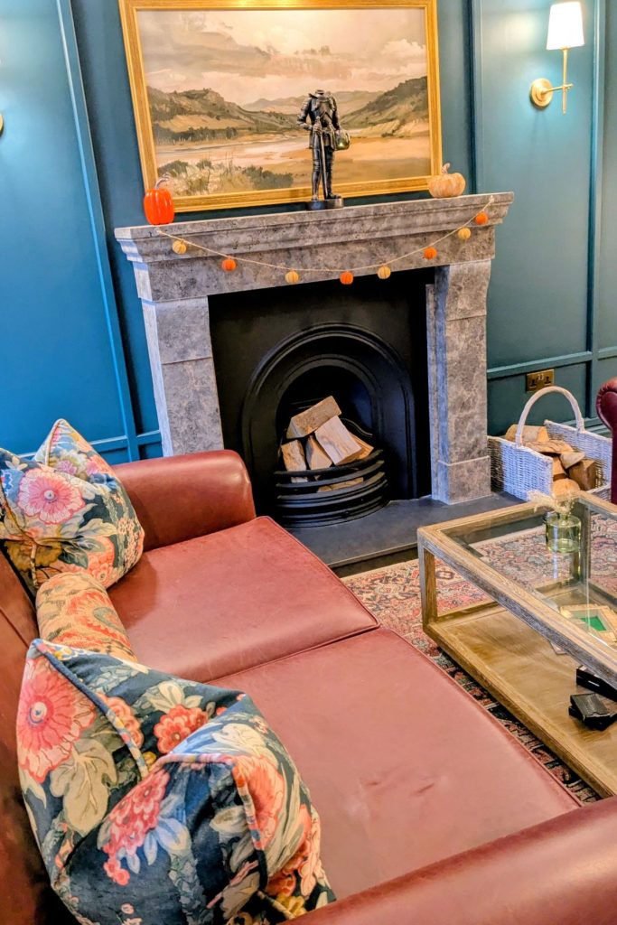 Sofa and open fire in the reception area at The Leddie