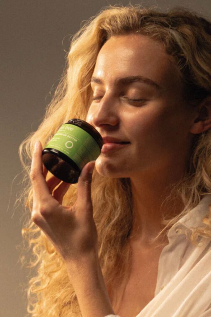 Woman smelling the aroma of the Sweet Bee Organics Magnesium Butter