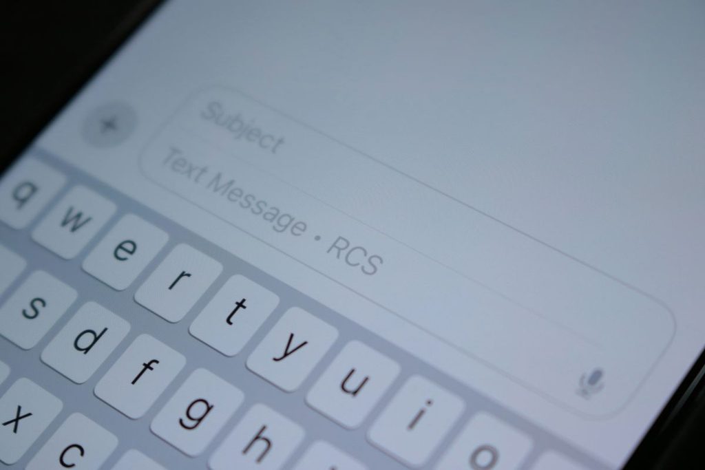 A smartphone showing a spam text warning on the screen